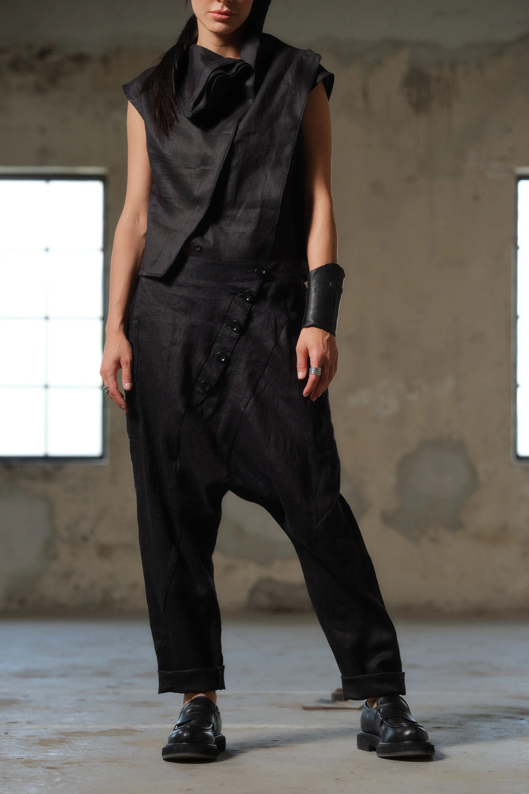 Front view of black linen pants with buttoned low-crotch design