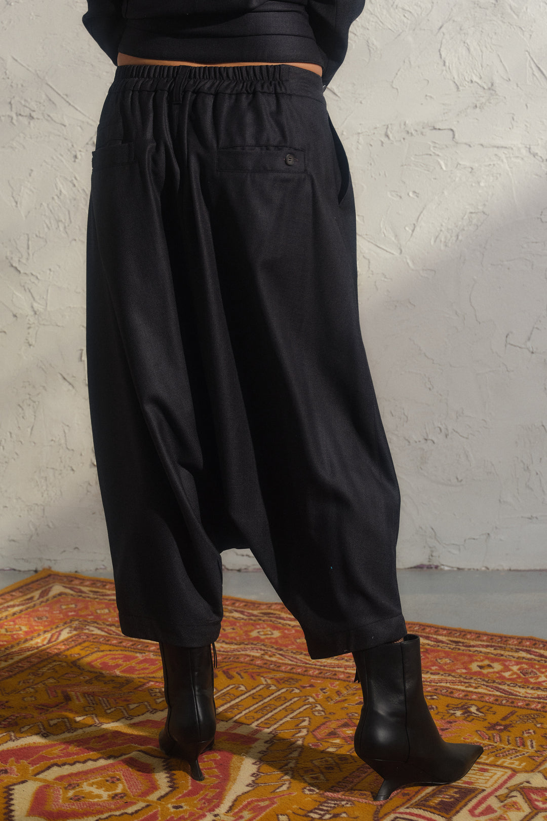 Schwarze Winterhose aus Wolle mit tiefem Schritt und asymmetrischen Details
