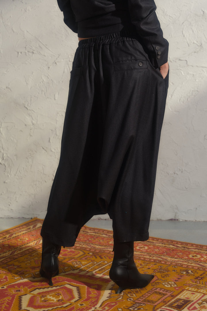 Schwarze Winterhose aus Wolle mit tiefem Schritt und asymmetrischen Details